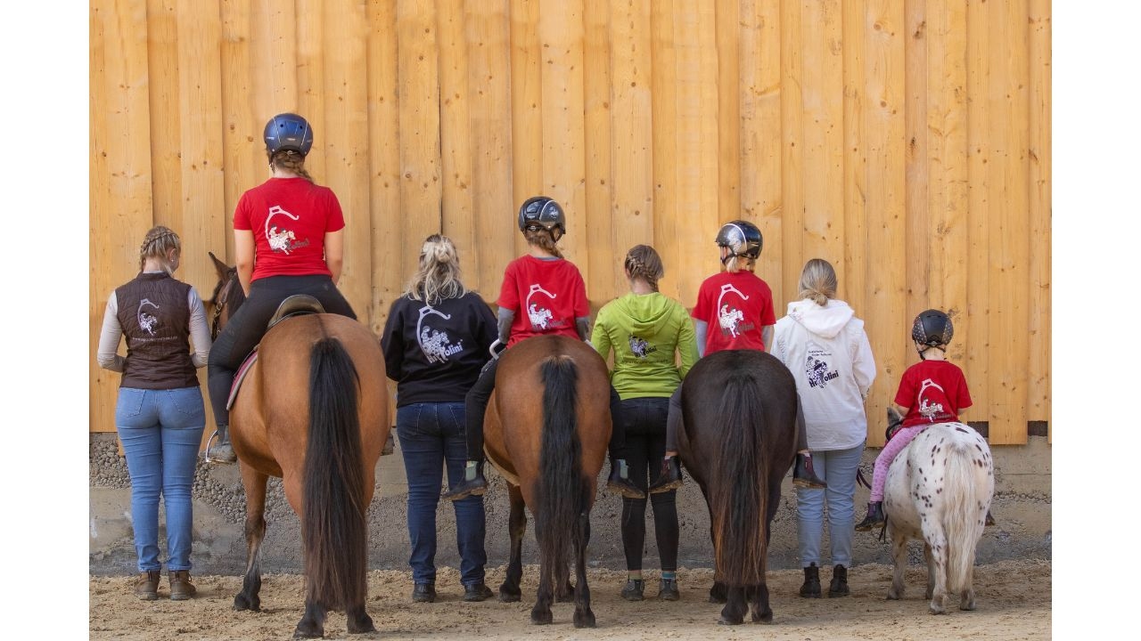 HIPPOLINI Reitlehrer begleiten Kinder auf Ponys, die zur Größe und zum Alter der Kinder passen